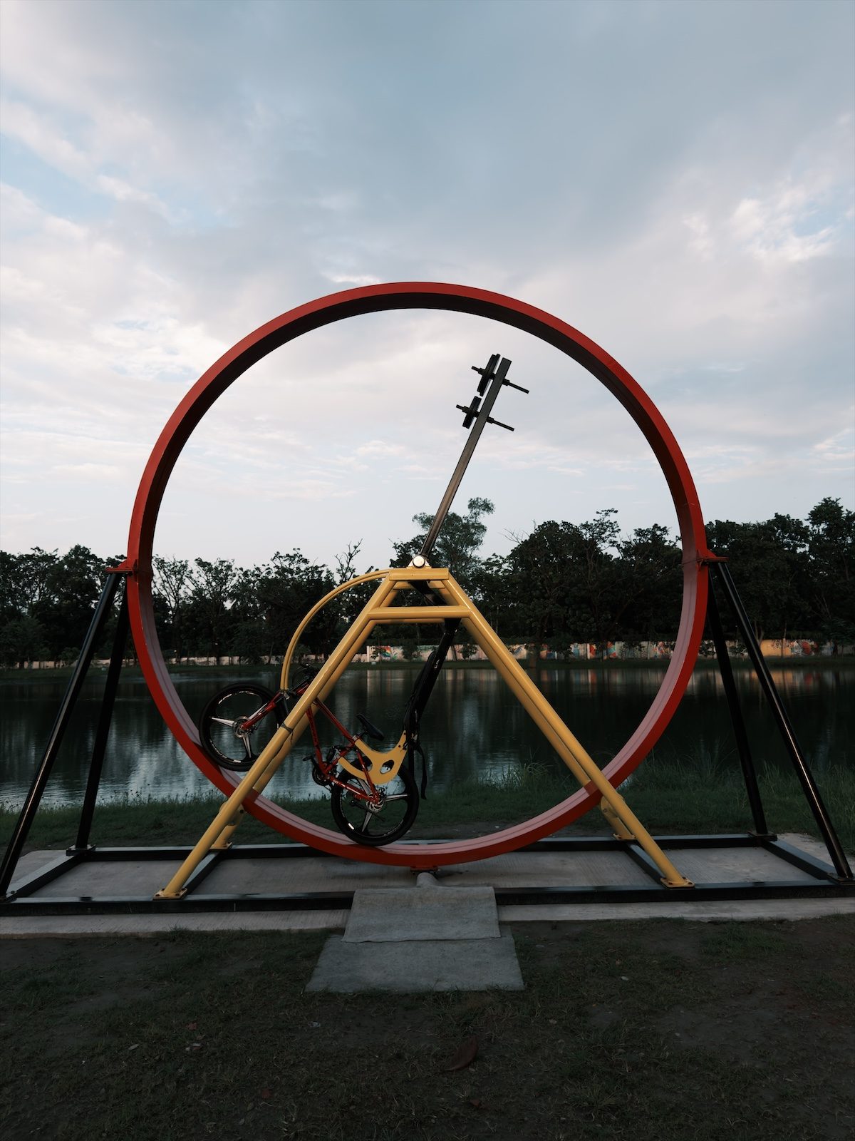 Eine rote Ringskulptur an einem See, entwickelt mit Chobial Negative