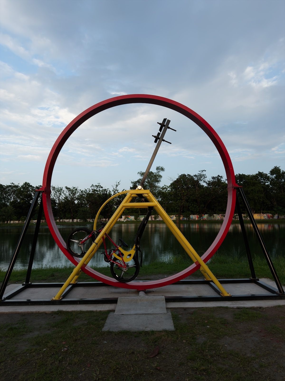 A red ring sculpture by a lake, clean develop