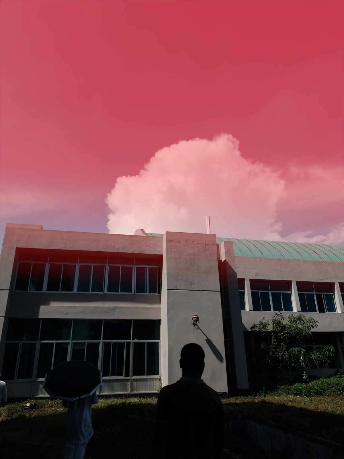 The building photo with red over the sky, fading to clear near the rooftop